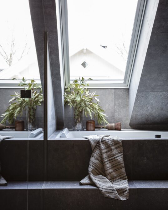 Detaljbilde fra bad med badekar og skråstilt vindu, utført av Lomundal.