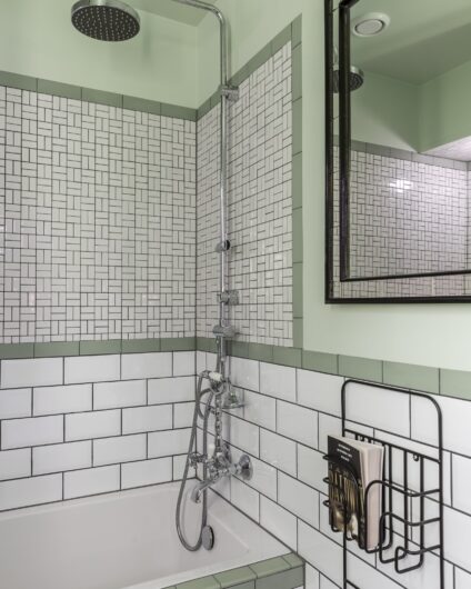 Detaljbilde fra bad med kombinasjon av hvite og grønne fliser, samt malte grønne flater, utført av Lomundal.