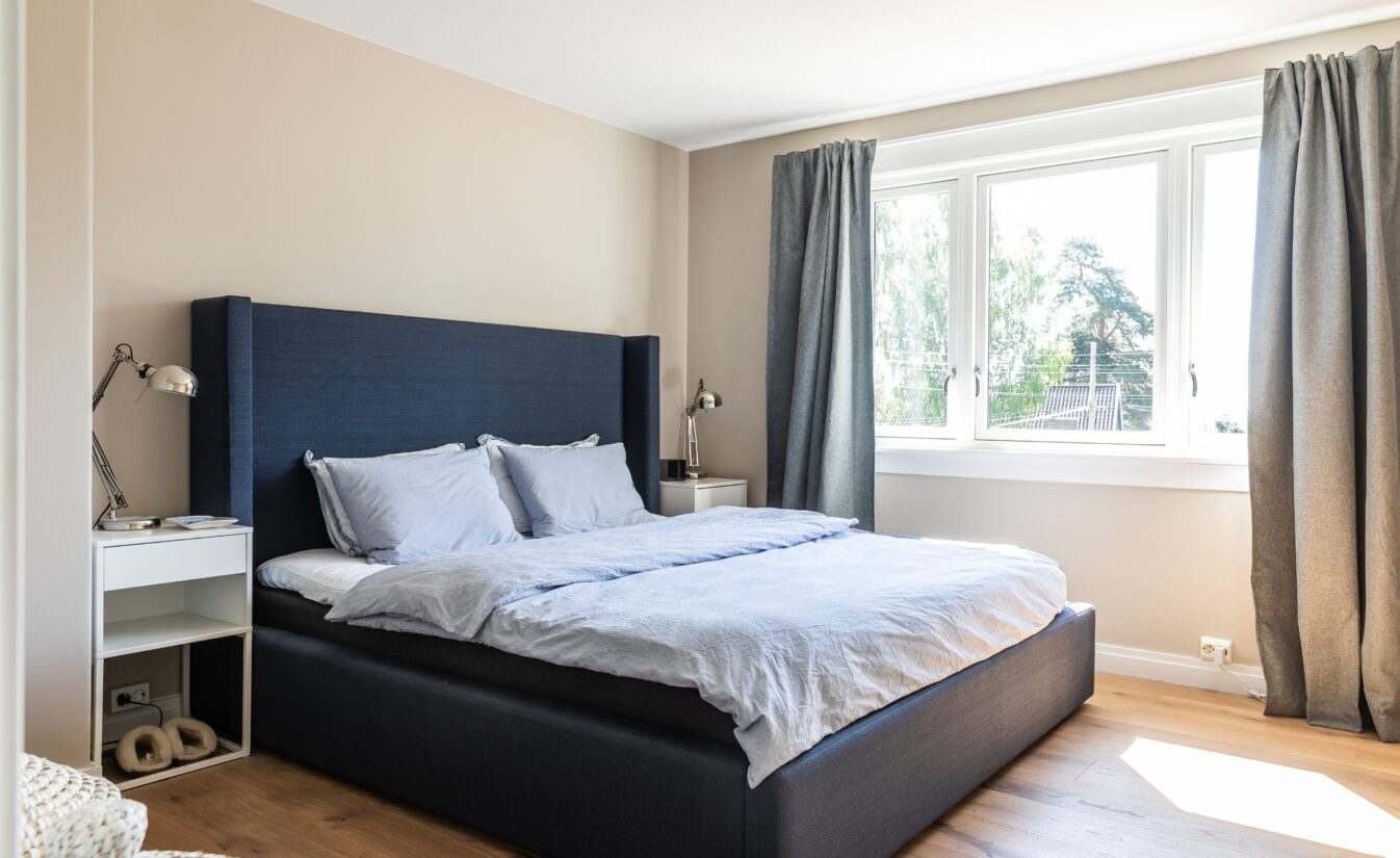 Hovedsoverom med ny enstavs parkett, malte flater og blå seng. Utført av Lomundal.