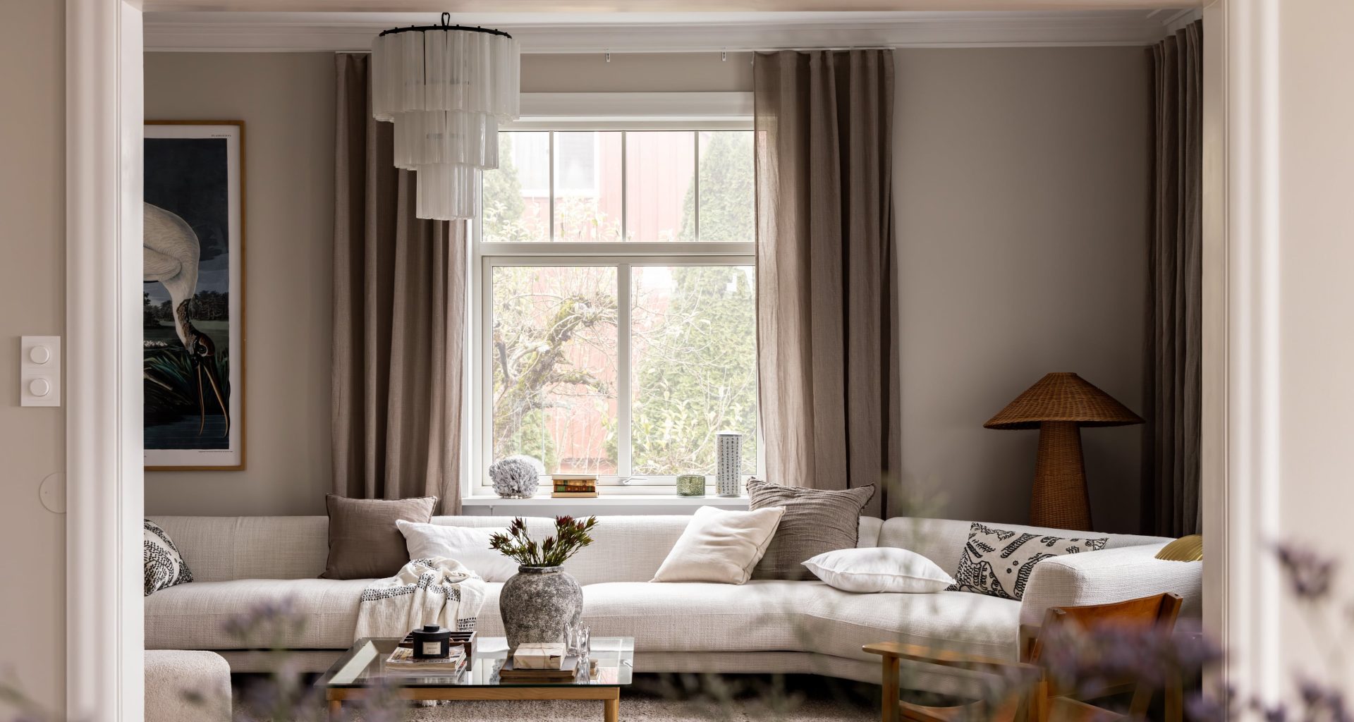 Stue i klassisk bolig på Bekkelaget i Oslo med lyse flater og fiskebensparkett. I rosetten henger en Murano lysekrone. Utført av Lomundal.