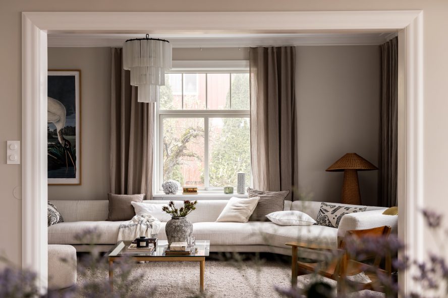 Stue i klassisk bolig på Bekkelaget i Oslo med lyse flater og fiskebensparkett. I rosetten henger en Murano lysekrone. Utført av Lomundal.