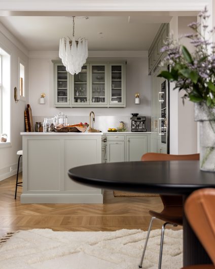 Kjøkken i klassisk bolig fra Kvänum i en dus grønnfarge. Boligen har klassisk fiskebensparkett og lyse flater.