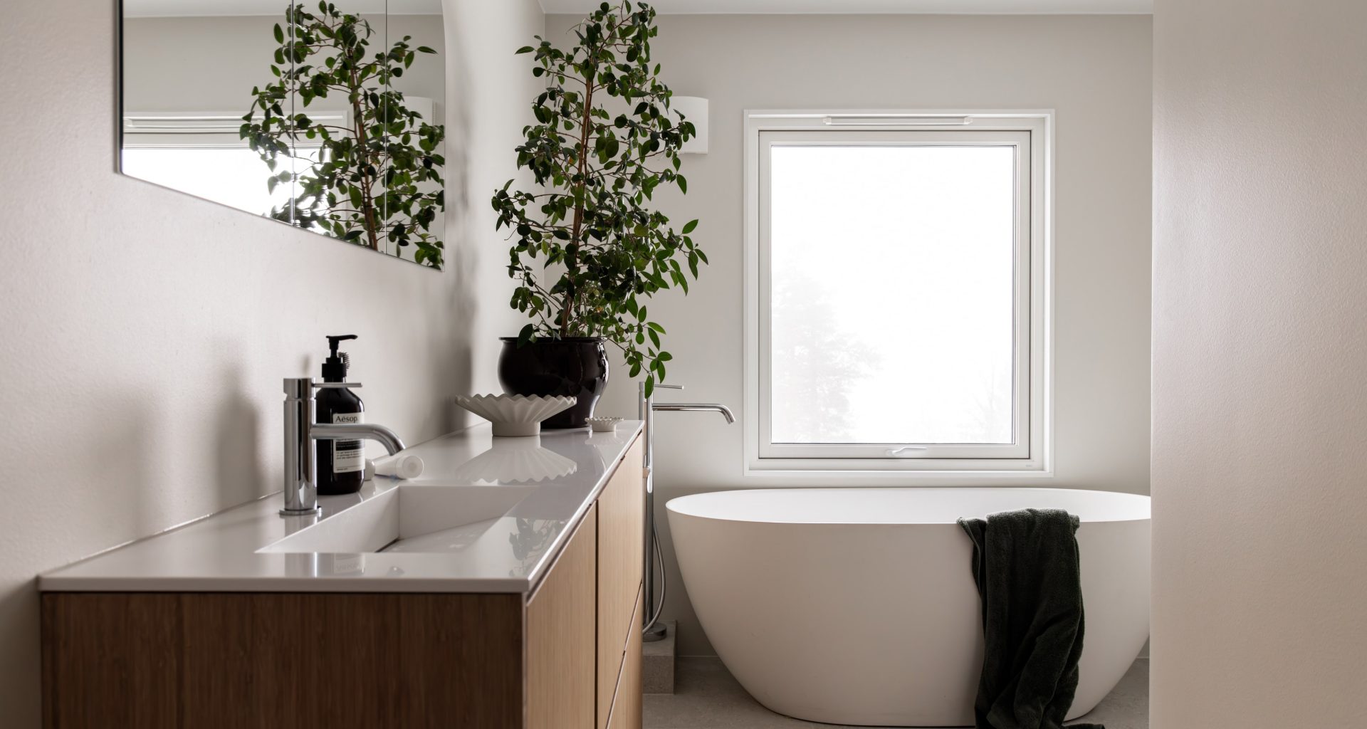 Master bad med en romslig følelse i naturlige fargetoner og badekar. Utført av Lomundal.