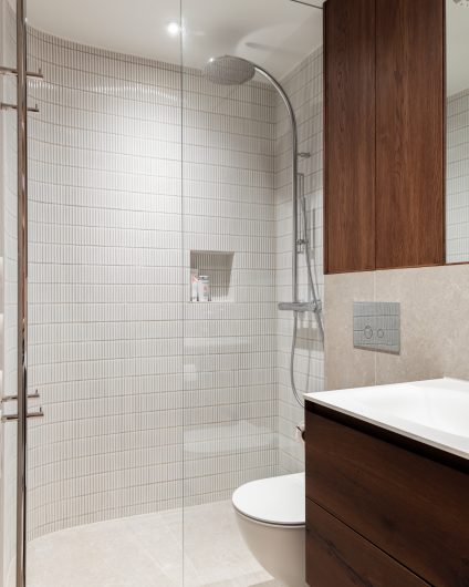 Klassisk bad med moderne og unike detaljer. Kombinert fliser på vegg i små og store formater og baderomsinnredning i mørkt treverk.