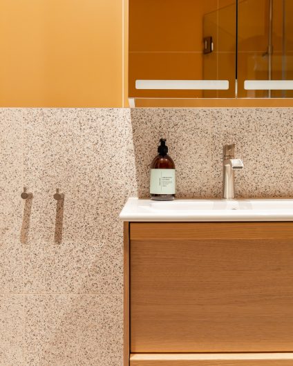 Et retro bad i varme fargetoner og med terrazzoflis. Badet er totalrenovert av Lomundal.