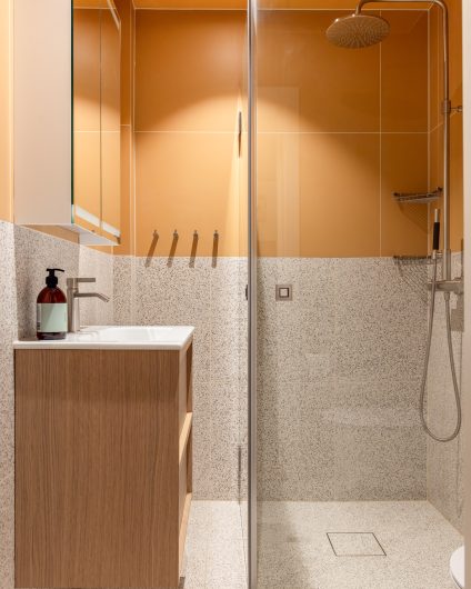 Et moderne bad med et retro og lekent uttrykk. Gulfargen og terrazzoflisene gir badet et unikt preg. Badet er totalrenovert av Lomundal.