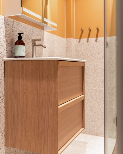 Baderomsinnredning i lyst treverk kombinert med terrazzoflis. Badet er totalrenovert av Lomundal.