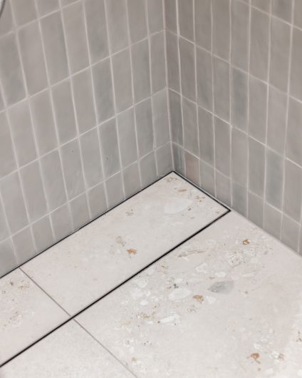 Lyst bad i Skandinavisk stil med terrazzoflis og matte mosaikkfliser. Utført av Lomundal.