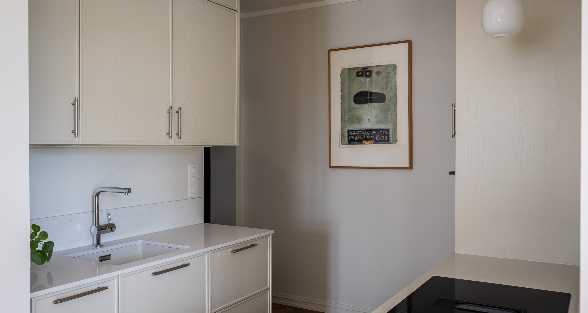 Et lyst kjøkken i skandinavisk stil. Kjøkkenet er i malt askefiner og skaper et klassisk men moderne uttrykk sammen med fiskebensparketten. Utført av Lomundal.