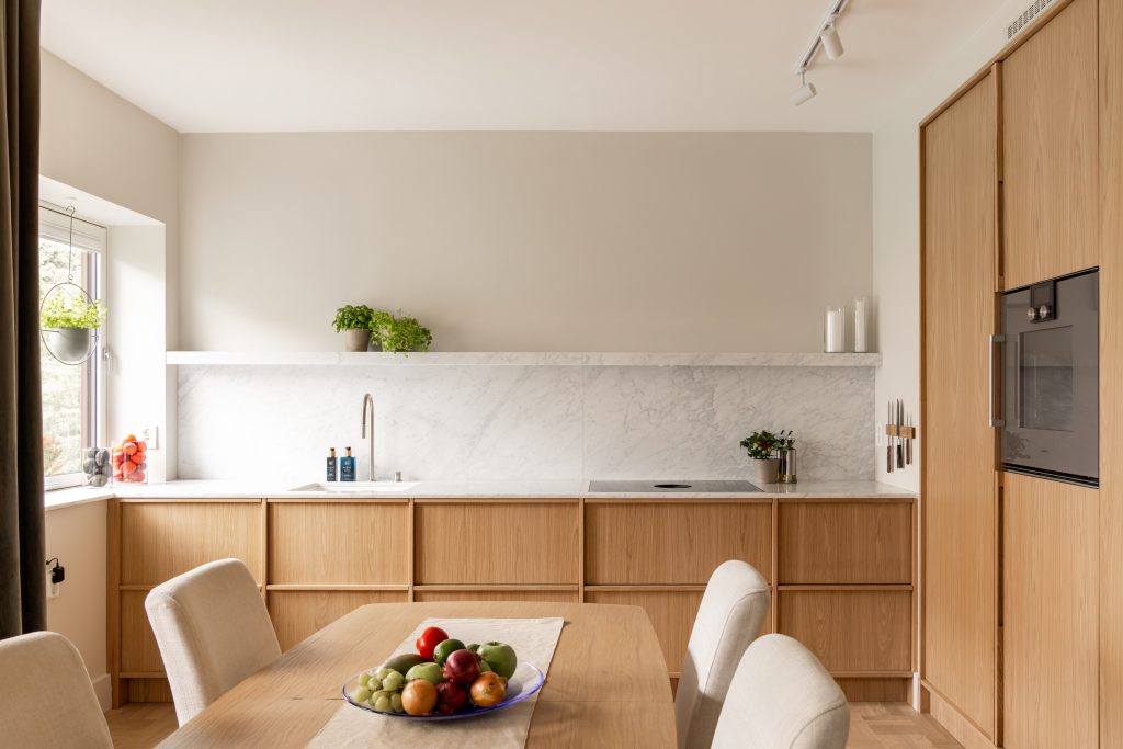 Skandinavisk kjøkken i lyst tre og benkeplate med marmoreffekt. Kjøkkenet har en stilren og minimalistisk innredning, og et luftig uttrykk. Utført av Lomundal.