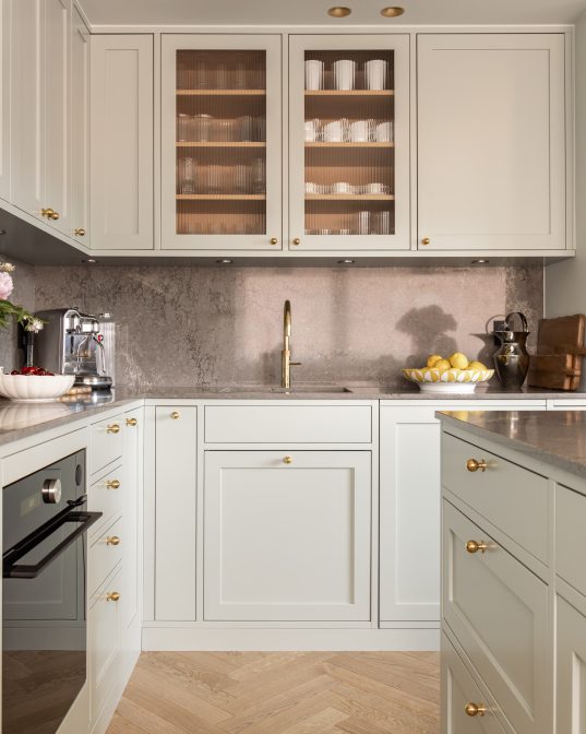 Klassisk kjøkken i en mintgrønn tone. Kjøkkenet har et klassisk uttrykk med profilerte kjøkkenfronter og rillet glass. Benkeplaten og backsplashet er i kvartskomposittstein som skaper en fin kontrast. Utført av Lomundal.