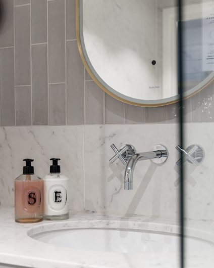 Moderne bad i gråtoner. Badet har et stilrent uttrykk med Carrara og blanke fliser på vegg. Utført av Lomundal.