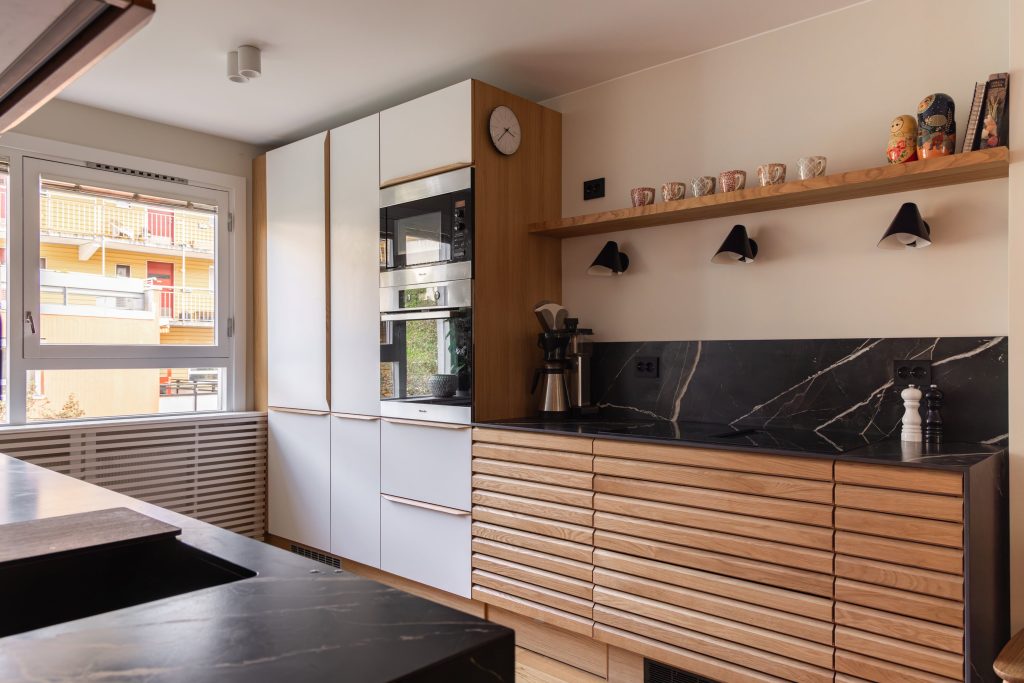 Lyst, nordisk kjøkken i eik. Eikelamellene og den keramiske benkeplaten skaper fine detaljer i rommet. Kjøkkenet er totalrenovert av Lomundal. Vi pusser opp bad og bolig i Stor-Oslo.