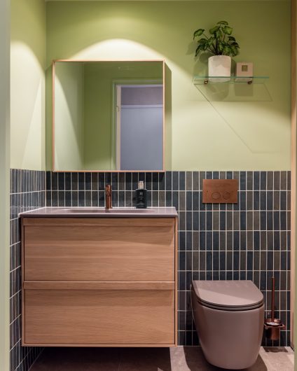 Lyst bad i friske farger. Badet kombinerer beige nyanser med lyst treverk, og vegger i grønntoner. Et moderne, nyoppusset bad med personlig uttrykk. Utført av Lomundal.