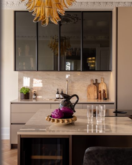 Kjøkken med eksklusivt uttrykk med en elegant benkeplate og innredning med skapdører. Utført av Lomundal.