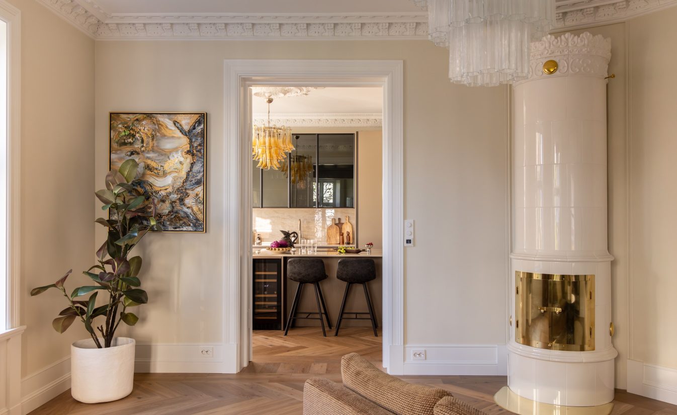 Stue i klassisk stil med et varmt og elegant uttrykk. Her finner man lekre stukkaturlister, rosett, og bred fiskebensparkett med rammer. Utført av Lomundal.