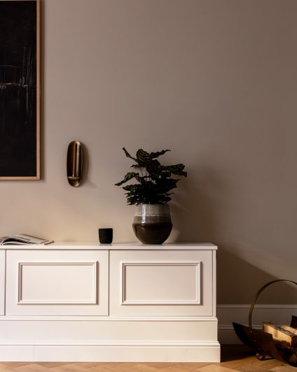 Klassisk TV-stue i beigetoner med klassiske detaljer. TVbenk med stukkaturlister som gir et klassisk og elegant uttrykk, og fiskebensparkett i en varm, lys fargetone. Utført av Lomundal.