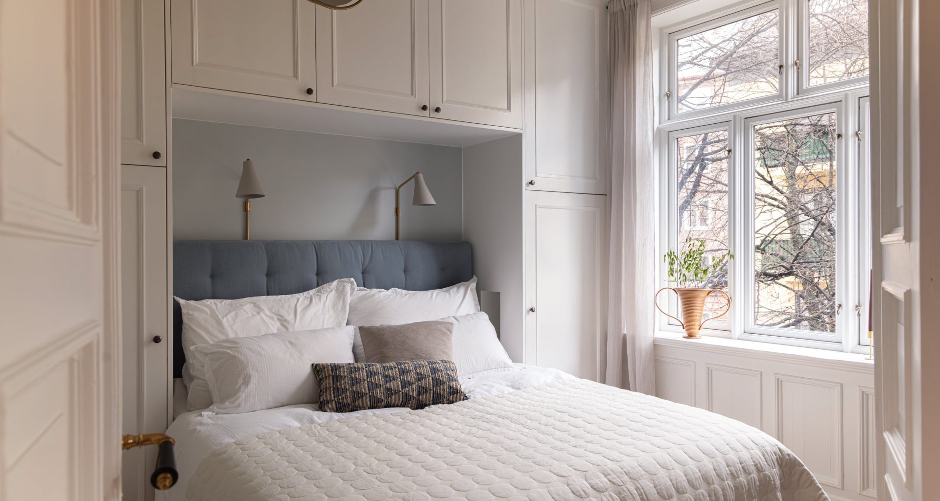 Soverom i klassisk stil med fiskebensparkett og brystning på vegg. Utført av Lomundal.