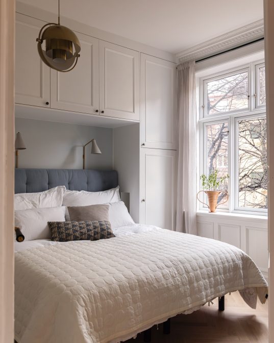 Soverom i klassisk stil med fiskebensparkett og brystning på vegg. Utført av Lomundal.