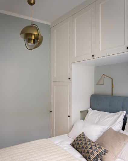 Lyst soverom i blåtoner med plassbygd garderobeskap med elegant listverk og rosett i taket. Utført av Lomundal.