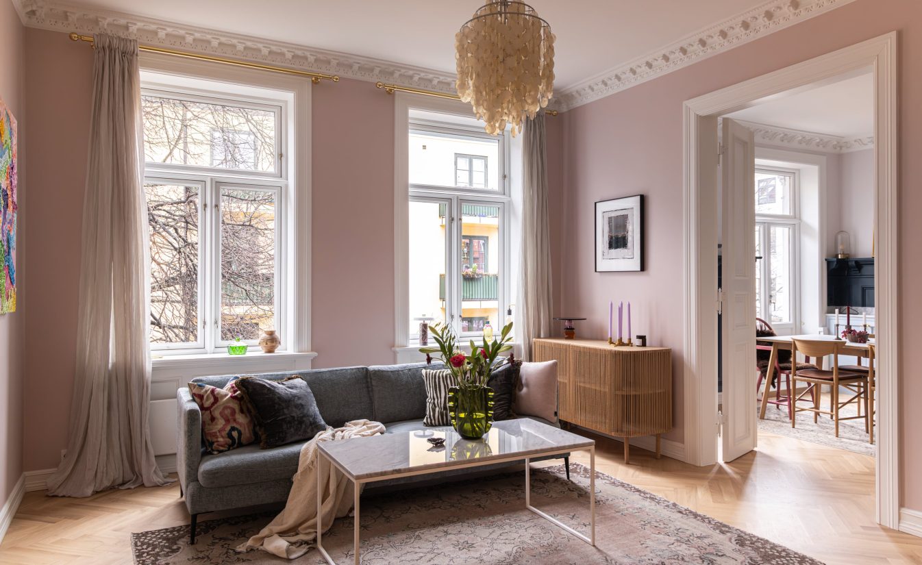 Lun stue i dus rosa, med stukkatur, brystning og fiskebensparkett som gir et klassisk uttrykk. Utført av Lomundal.