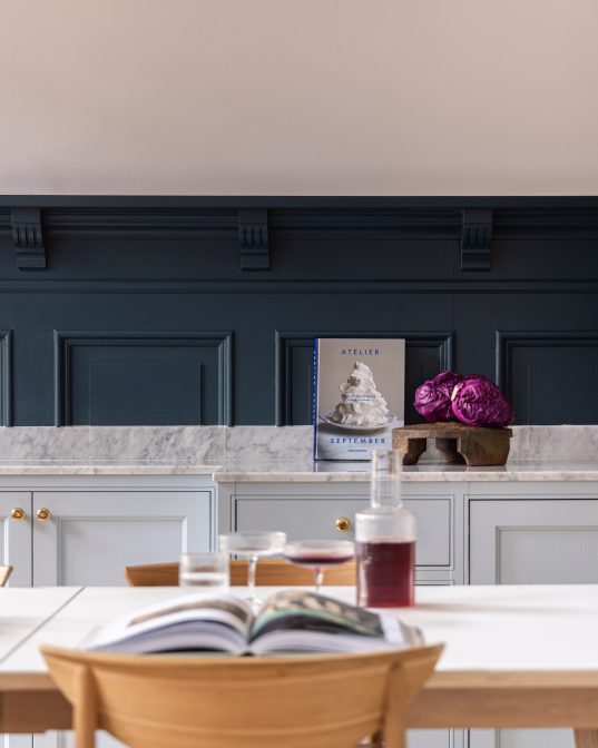 Kjøkken i klassisk stil i blåtoner med brystning, benkeplate i Carrara marmor og detaljer i messing. Utført av Lomundal.