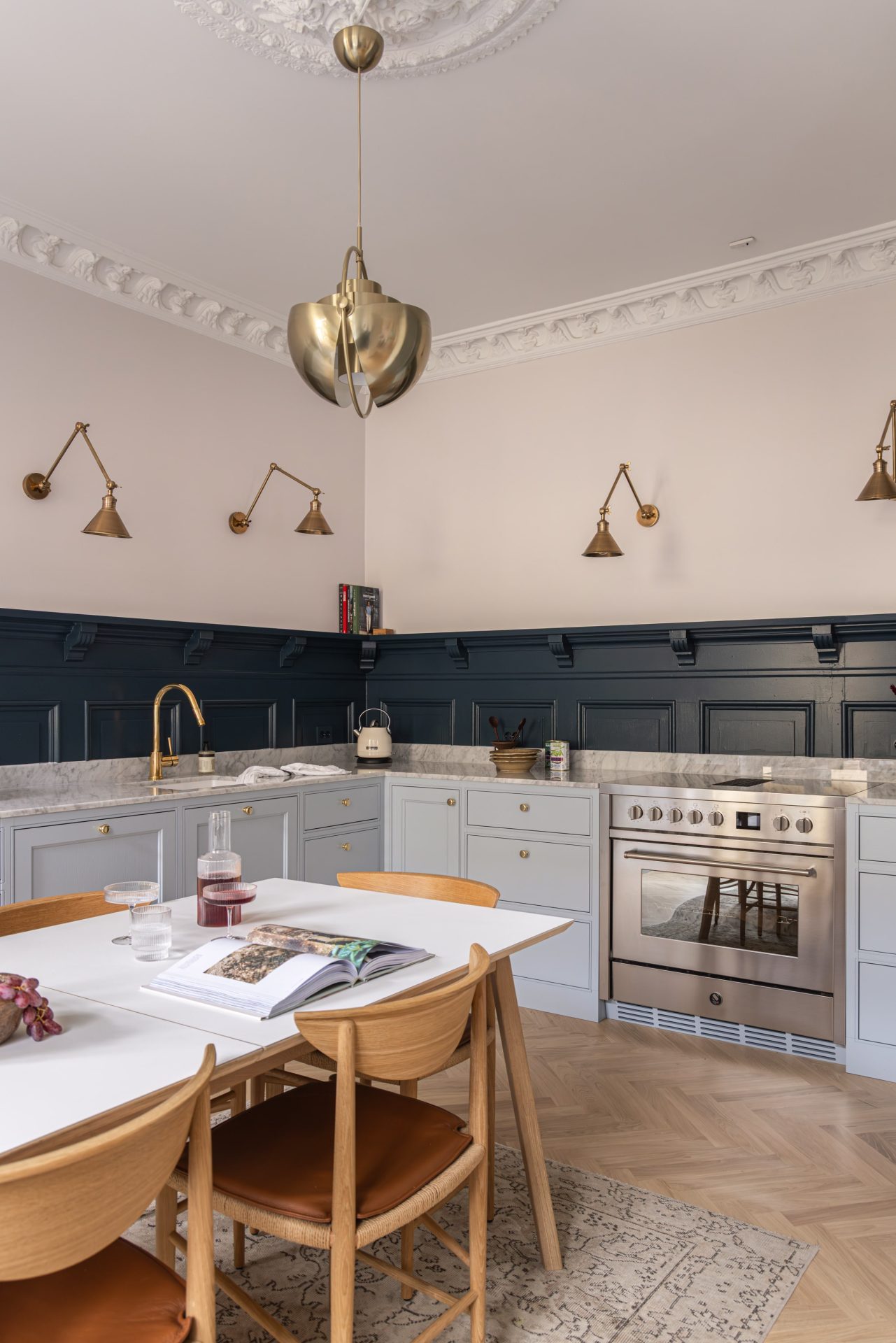 Et elegant kjøkken i blåtoner med et klassisk uttrykk. Kjøkkenet har lekre detaljer i messing som tilfører eksklusivitet i uttrykket. Utført av Lomundal. - Bilde