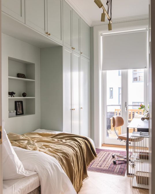 Soverom i grønntoner med plassbygd garderobeskap og fiskebensparkett. Utført av Lomundal.