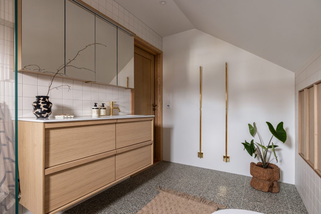 Bad i lyse toner med terrazzoflis og detaljer i messing