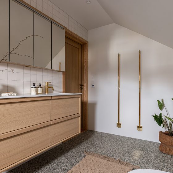 Bad i lyse toner med terrazzoflis og detaljer i messing