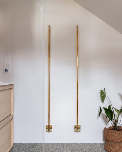 Bad med et lyst uttrykk, med hint av varme elementer som vegghengte håndkletørkere i oksidert messing. Utført av Lomundal.