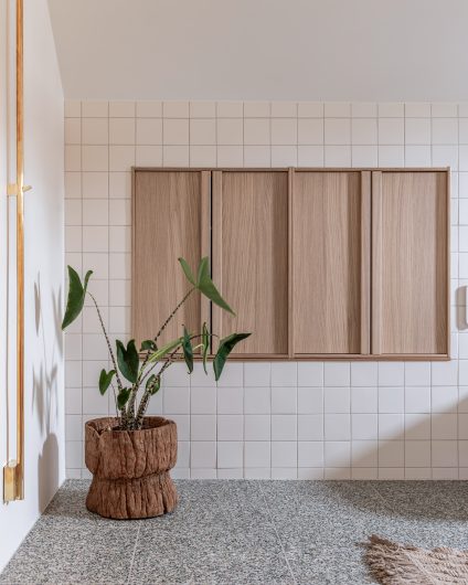 Stilrent, lyst bad med terrazzofliser på gulv og små kvadratiske fliser på vegg som skaper et dynamisk uttrykk. Utført av Lomundal.