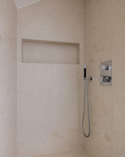 Dusjsone med store fliser i beigetoner med naturlige variasjoner i mønster, stor dusjnisje og tidløst armatur i krom. Totalrenoveringen er utført av Lomundal.