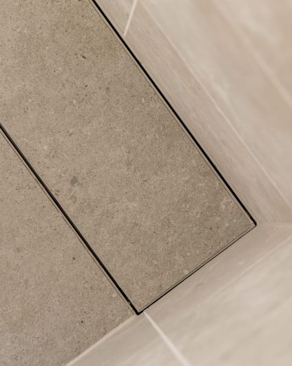 Detaljbilde av flislagt sluk i dusjsone. Totalrenoveringen er utført av Lomundal.