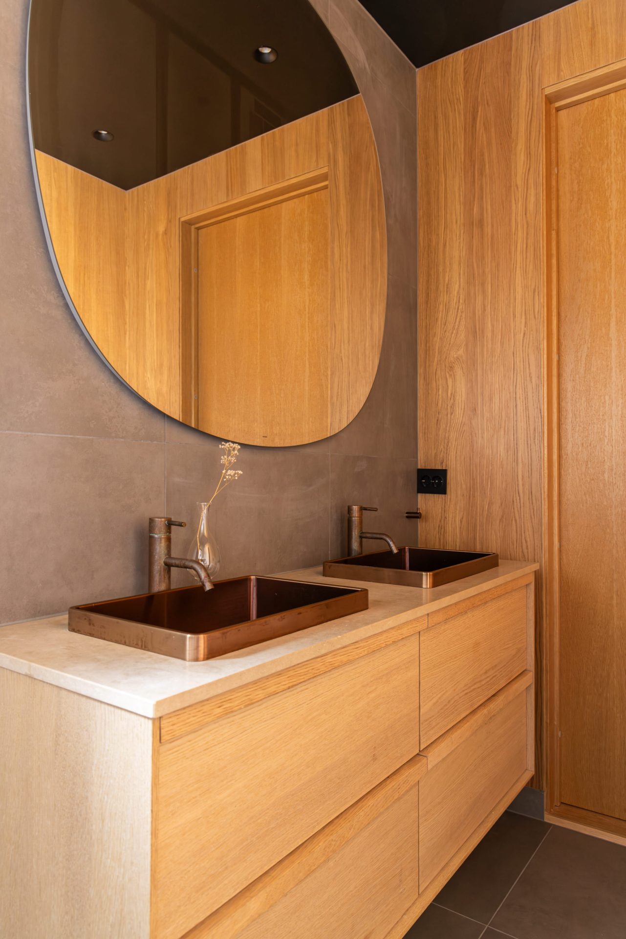 Moderne bad med betong look, mørke fliser og eikefinér på vegger. Et behagelig bad med spafølelse og en lun atmosfære. Utført av Lomundal. - Bilde