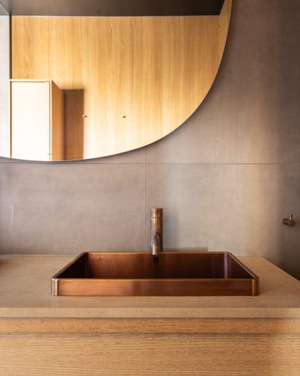 Moderne bad med et røft, naturlig uttrykk. Kundene ønsket et bad som sto i stil til huset, med betonginspirerte fliser og treverk. Utført av Lomundal.