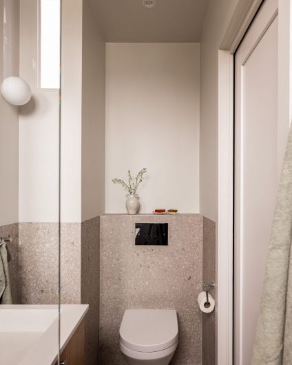 Et lyst og minimalistisk gjestebad med toalett, vask og dusj i skandinavisk stil. Badet er totalrenovert av Lomundal.
