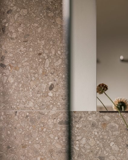 Detaljbilde av fliser i dusjsone på et skandinavisk bad. Badet er totalrenovert av Lomundal.