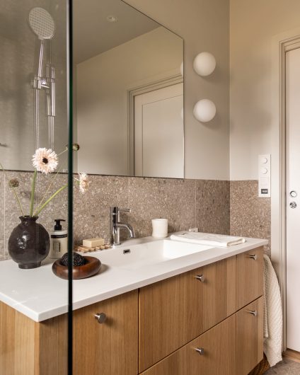 Et skandinavisk bad med organisk uttrykk som kombinerer malte flater og terrazzoflis. Badet har et naturlig og dynamisk uttrykk. Badet er totalrenovert av Lomundal.