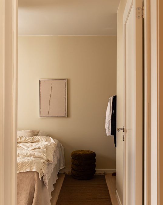 Soverom med beige vegger med et sømløst og minimalistisk uttrykk. Soverommet er totalrenovert av Lomundal.