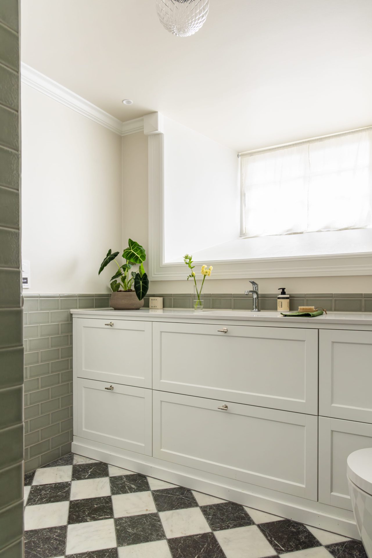 Klassisk baderomsinnredning med profilerte fronter og benkeplate i stein. Badet har et klassisk og elegant uttrykk, med et tidløst fargepalett. Utført av Lomundal. - Bilde