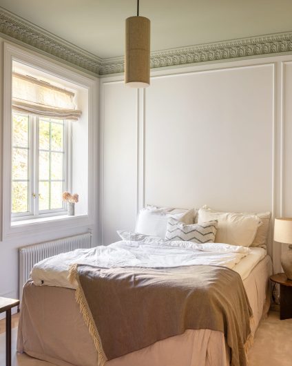 Soverom i bygårdsleilighet i klassisk stil. Soverommet har gulvteppe, lyse vegger og et elegant tak malt i en dus grønntone. Utført av Lomundal.