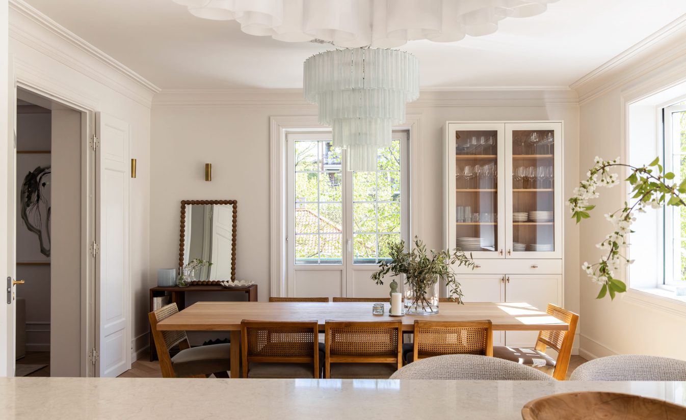 Et lyst kjøkken og spisestue i klassisk stil, med elegante detaljer og et tidløst uttrykk som passer bygården. Utført av Lomundal.