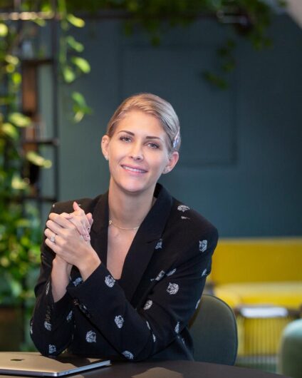 Bilde av kvinne som sitter i kontorlokale, Camilla Bentzen i Ramsøskar Interiørarkitekter