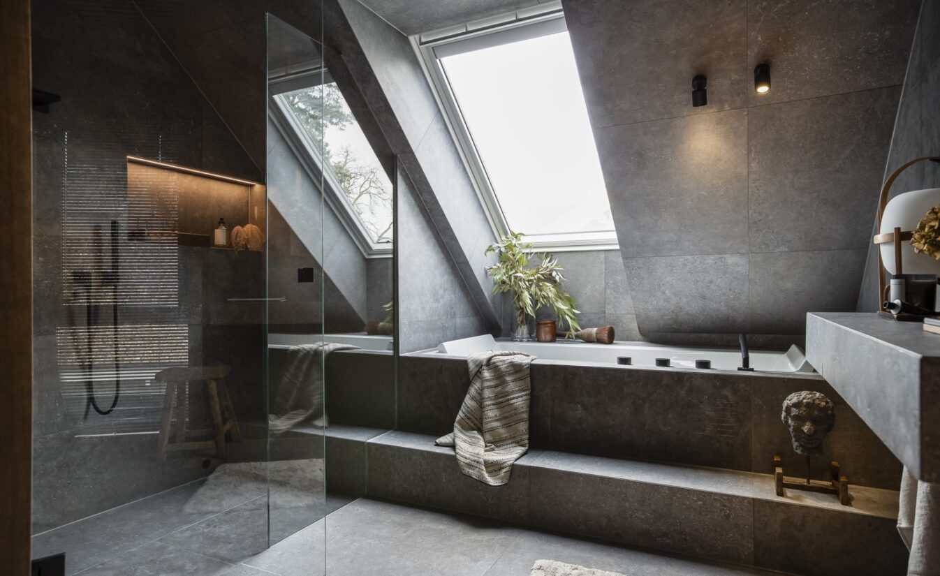 Badekar med store grå fliser, utført av Lomundal.