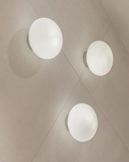 Detaljbilde av veggmonterte runde lamper, utført av Lomundal.