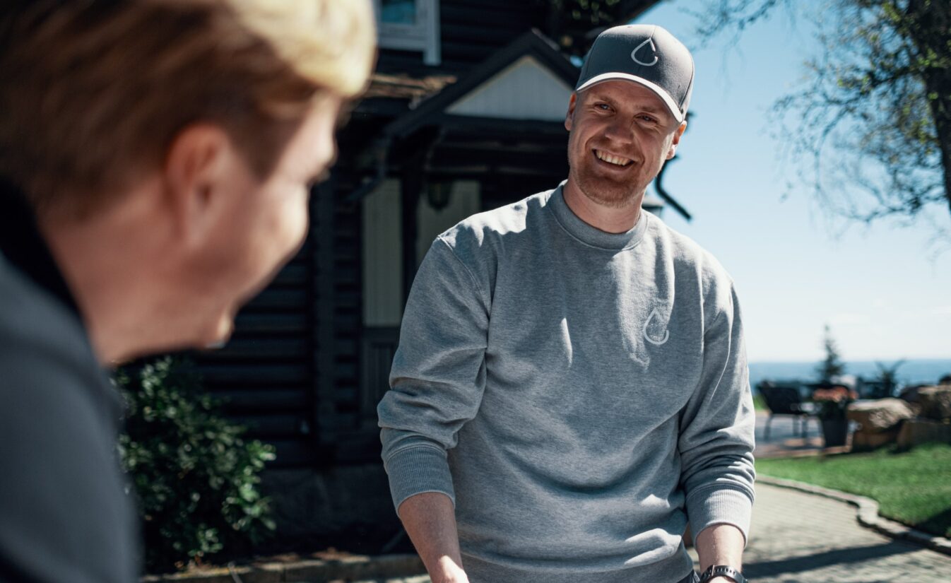 Simen smiler til Amund. De står utenfor et prosjekt for Lomundal.