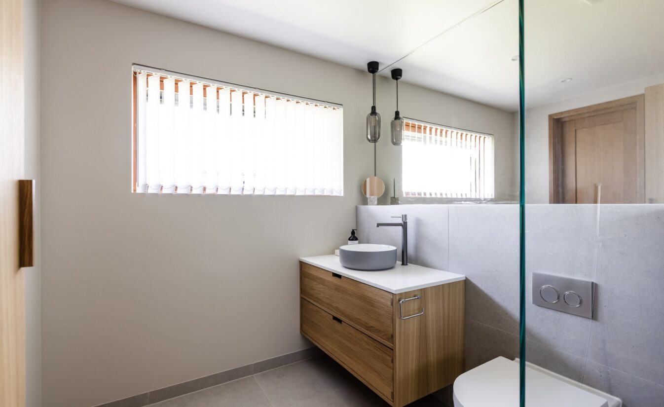 Bad med vindu, baderomsmøbel i eik, frittstående vask og pendellampe i tak. Utført av Lomundal.
