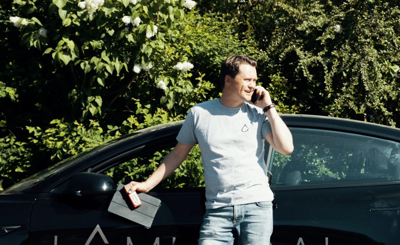 Johan er selger hos Lomundal og står ved bilen sin for å ta en telefonsamtale.