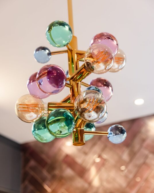 Detaljbilde av art deco lampe i taket i messing. Kjøkkenet er totalrenovert av Lomundal.